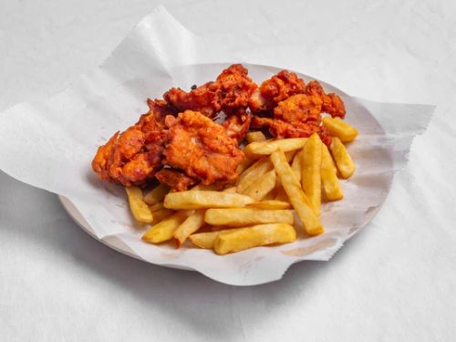 Crispy fried chicken wings and golden fries served with tangy sauces on a vibrant platter.